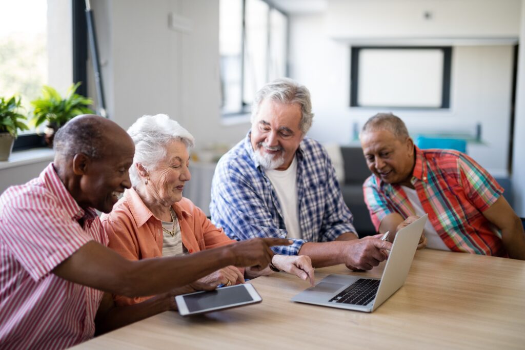 vier Senioren suchen online nach einem Umzugsunternehmen