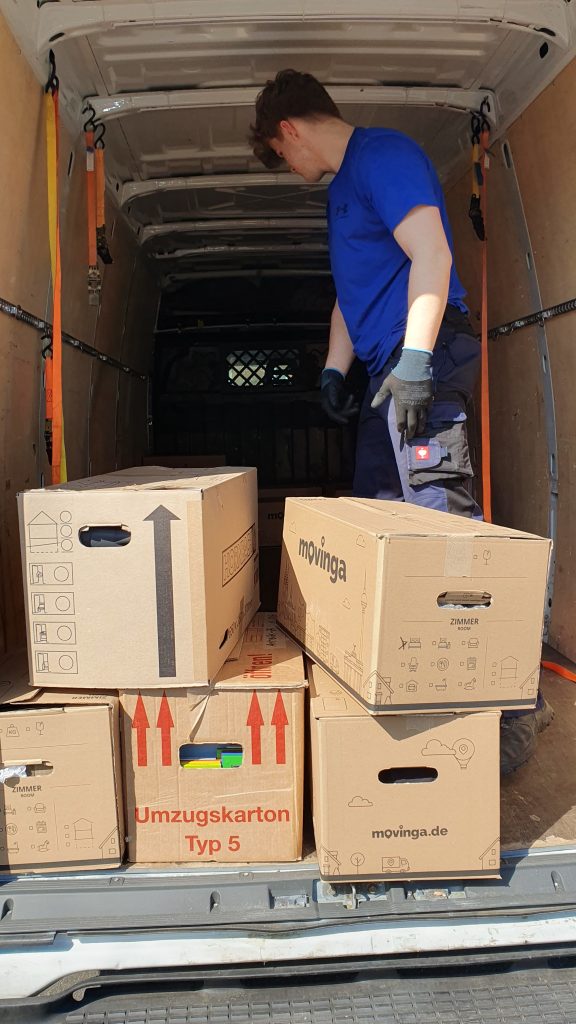 Mitarbeiter von Seniorenumzüge Lüneburg räumt Umzugskartons in einen Lieferwagen ein