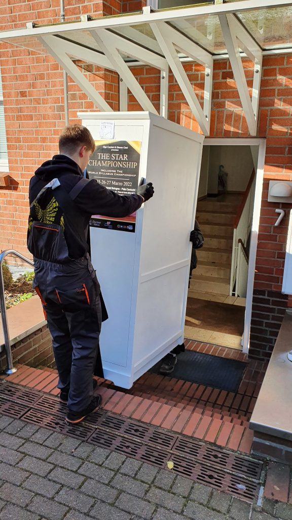 Mitarbeiter von Seniorenumzüge Lüneburg tragen einen Schrank aus einem Haus