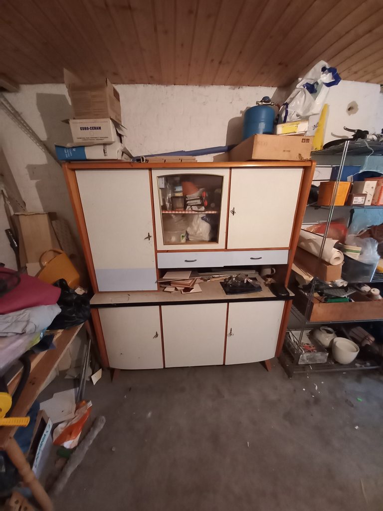 Ein alter Schrank in einem Keller, der vor einem Umzug entsorgt werden soll